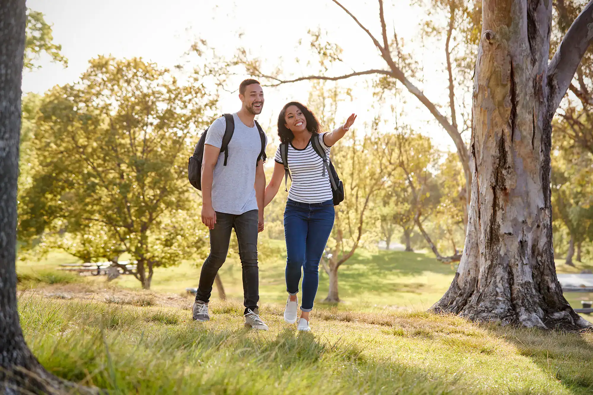 couple-wearing-backpacks-hiking-in-park